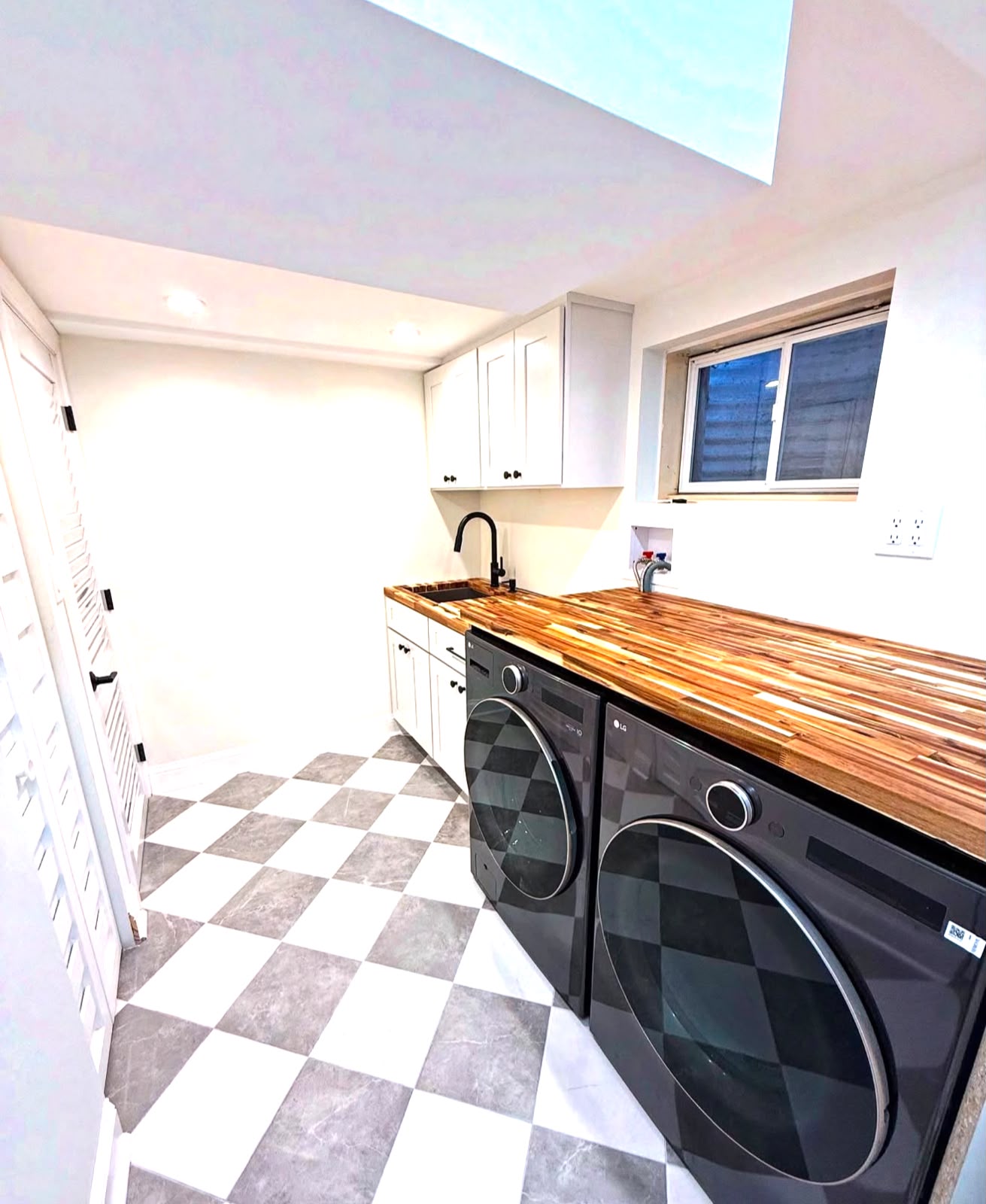 After photo of a bright renovated laundry room with new cabinetry and benchtop